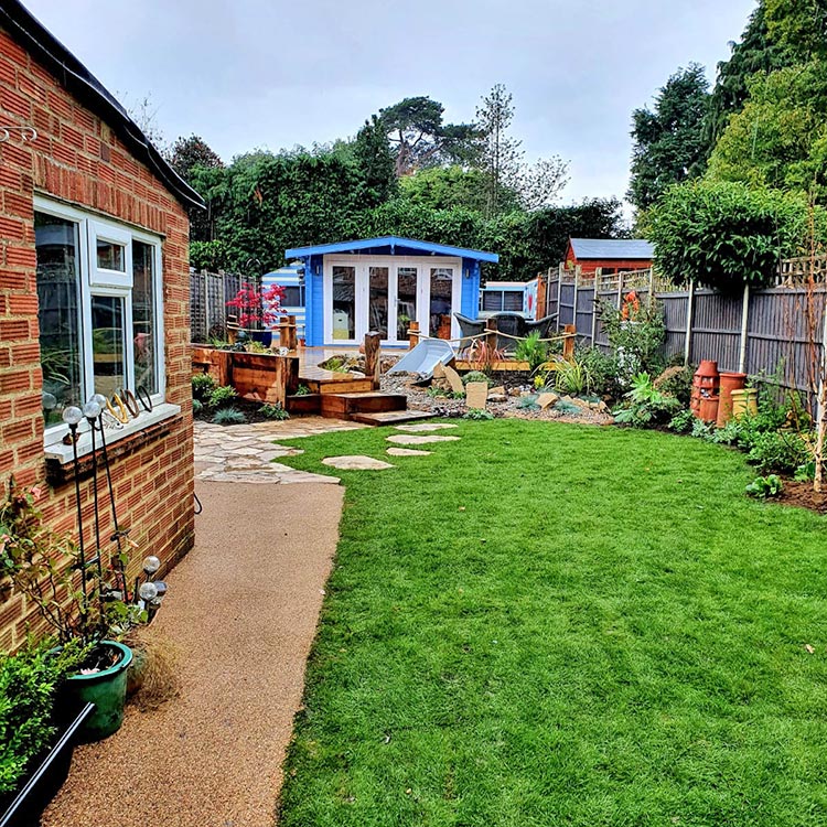 Restyled garden with hints of shoreline with summer house painted in seaside blue